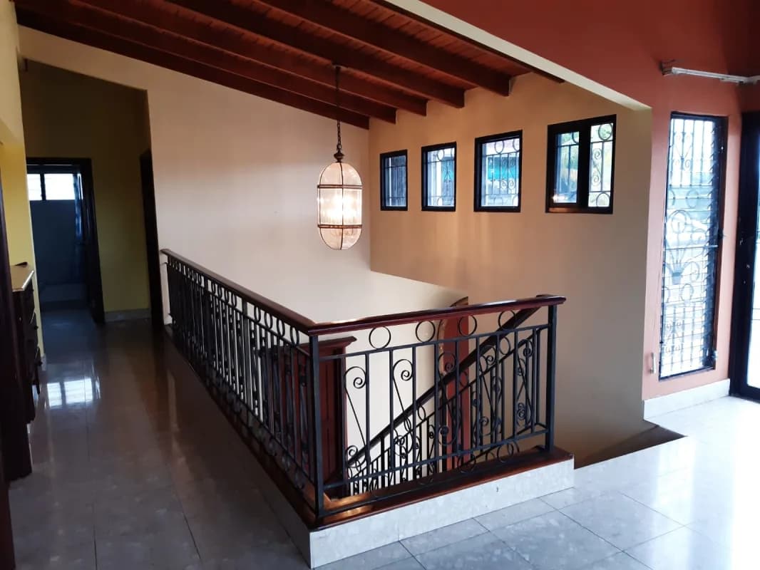 Interior corridor with exposed wooden beams and decorative iron railings PH Torres de Toscana Panama
