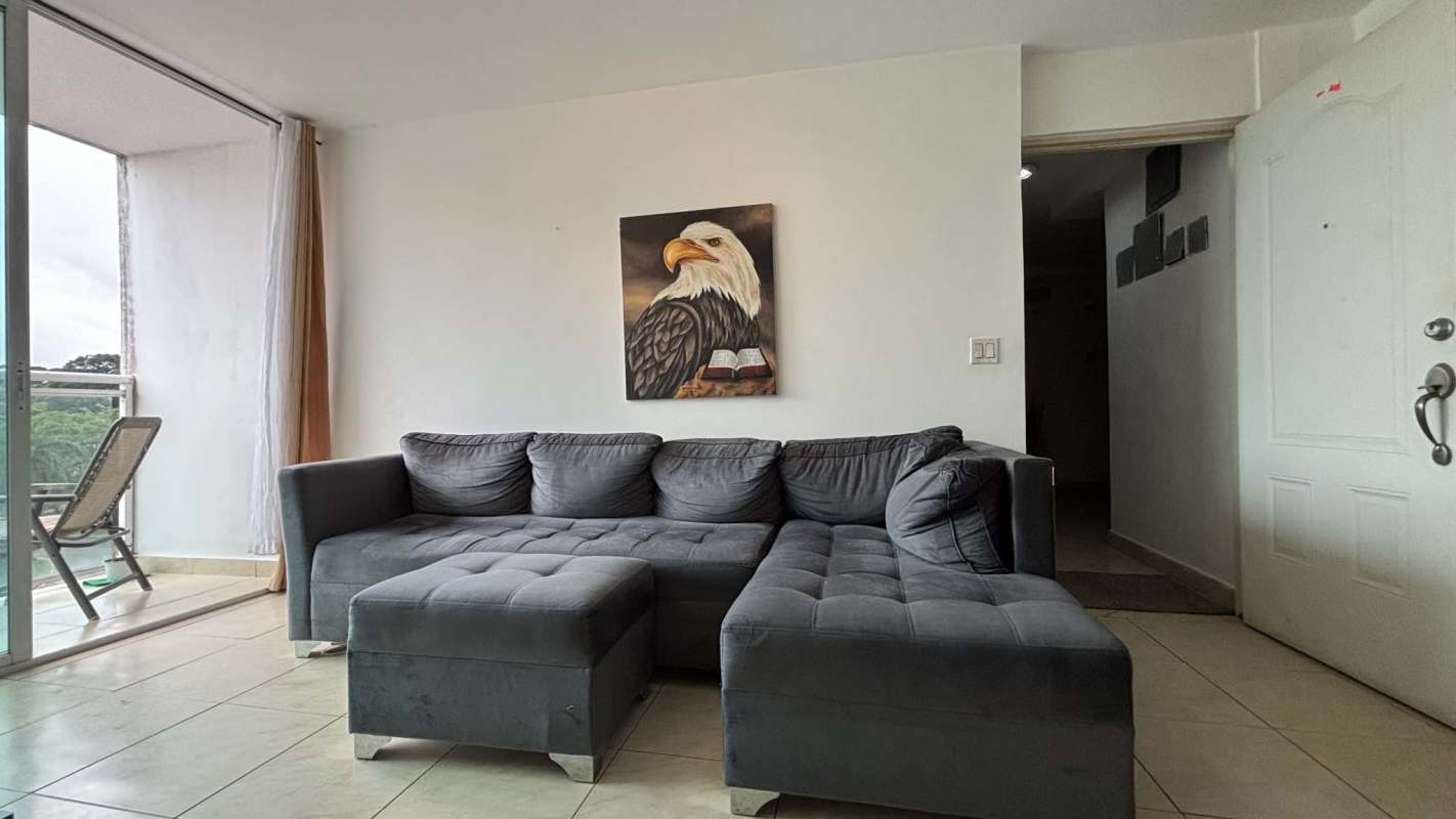 Modern living room with sectional sofa balcony door urban view PH Albrook Point Panama City