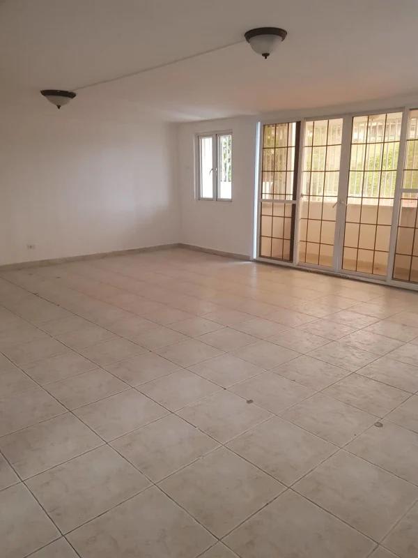 Spacious living room with balcony access and tiled floors in PH Torres de Toscana Panama