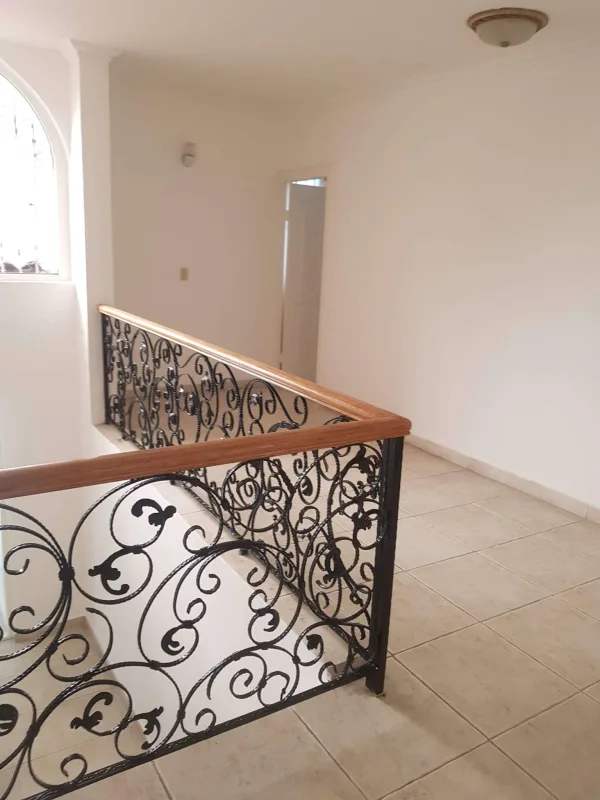 Hallway landing with arched window and wrought iron in Toscana Panama