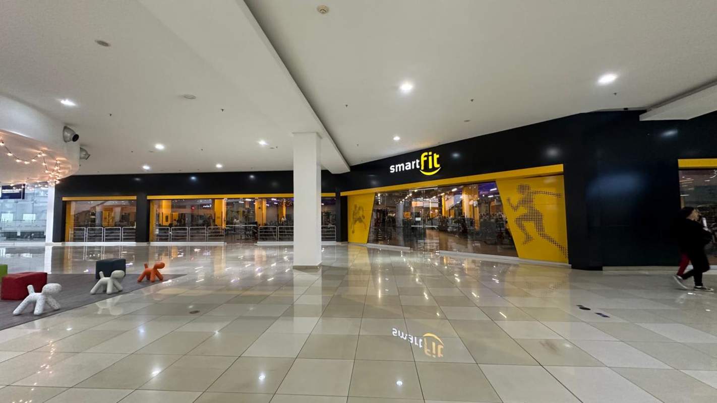 Wide corridor with Smart Fit gym entrance, glass panels and vibrant signage Mall Los Andes Panama