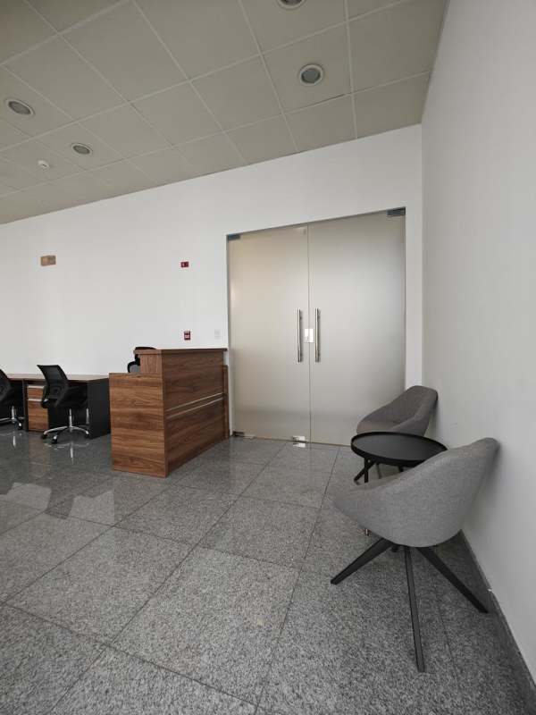 Reception area with wooden counter, glass doors and seating PH Bella Vista Office Center Panama