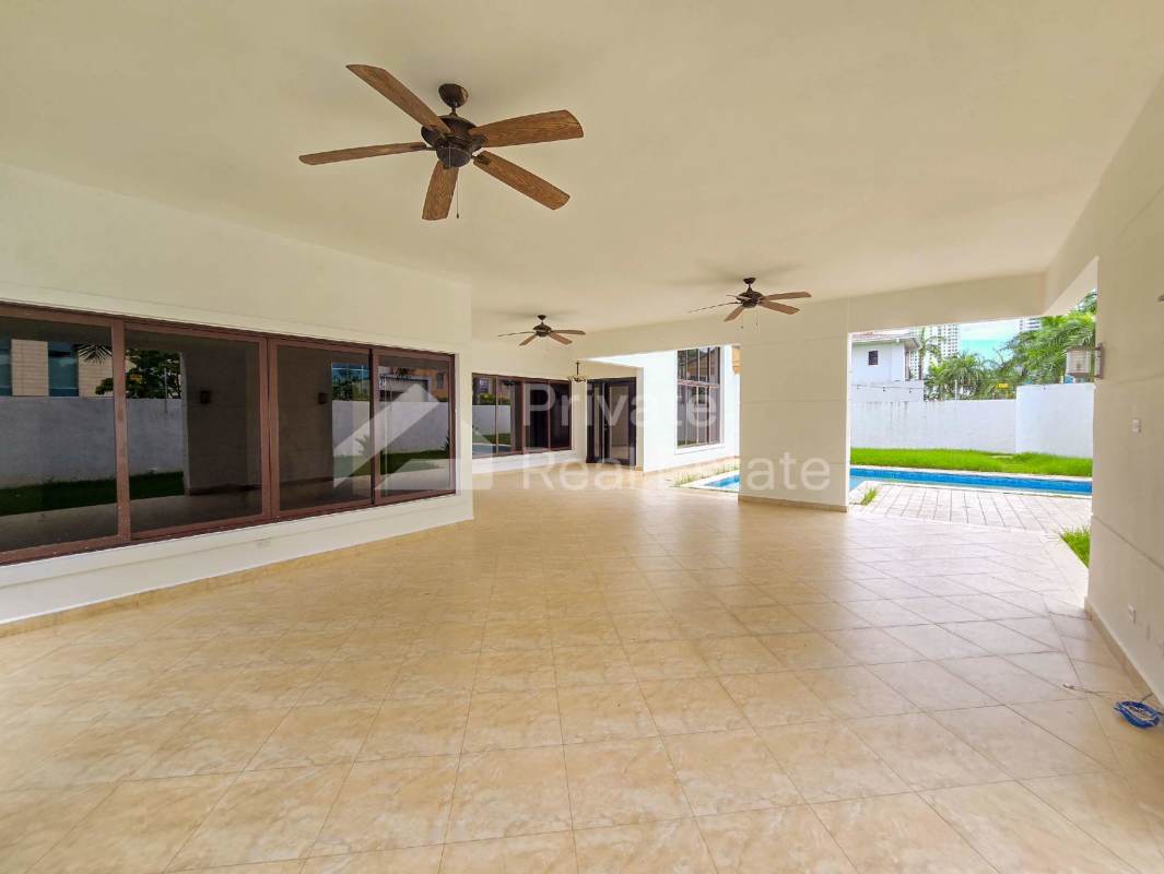 Spacious covered terrace with ceiling fans overlooking swimming pool and garden in luxury villa Costa del Este Panama