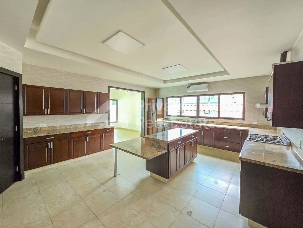 Grand living room with double-height ceiling, marble floors and large windows overlooking garden in luxury villa Costa del Este
