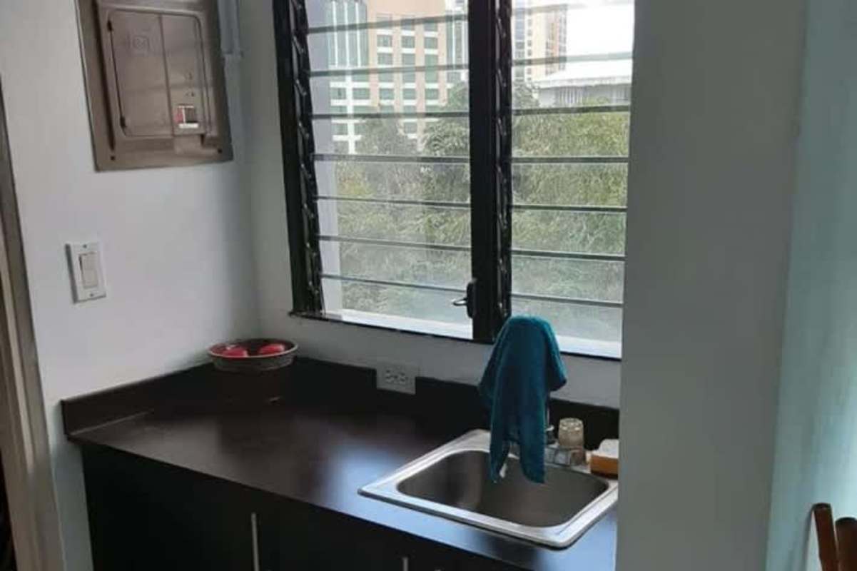 Minimalist kitchen corner with window, stainless sink and city view in Financial District Panama City