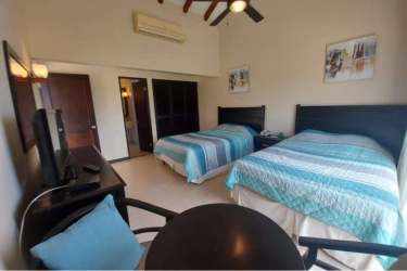 Guest bedroom with balcony access in golf villa Decameron Panama