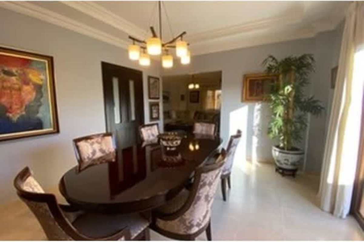 Elegant dining room with chandelier, oval table, double doors and natural light in Rainforest Villas Betania Panama