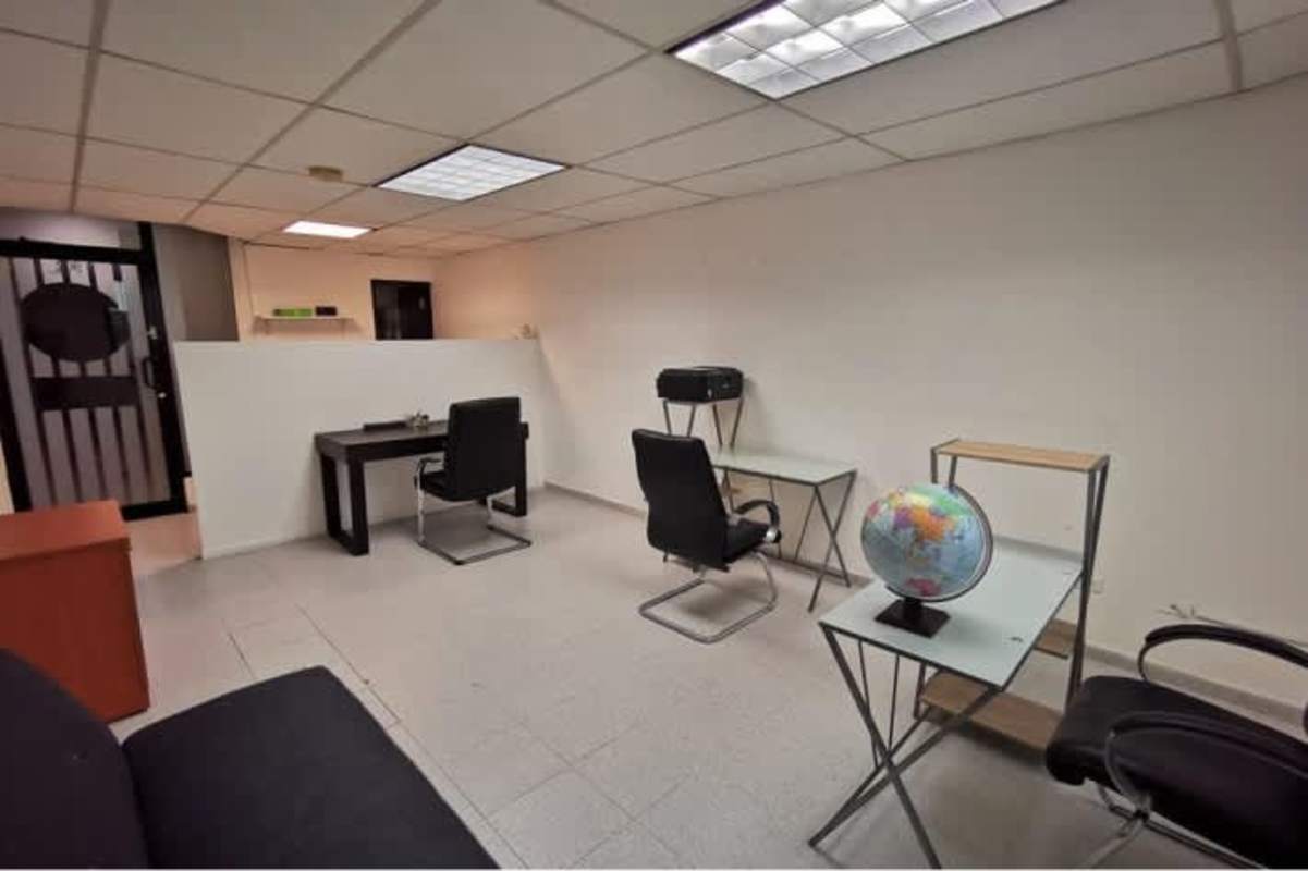 Open plan office with glass desk, black chairs, globe decor at International Business Center Tower