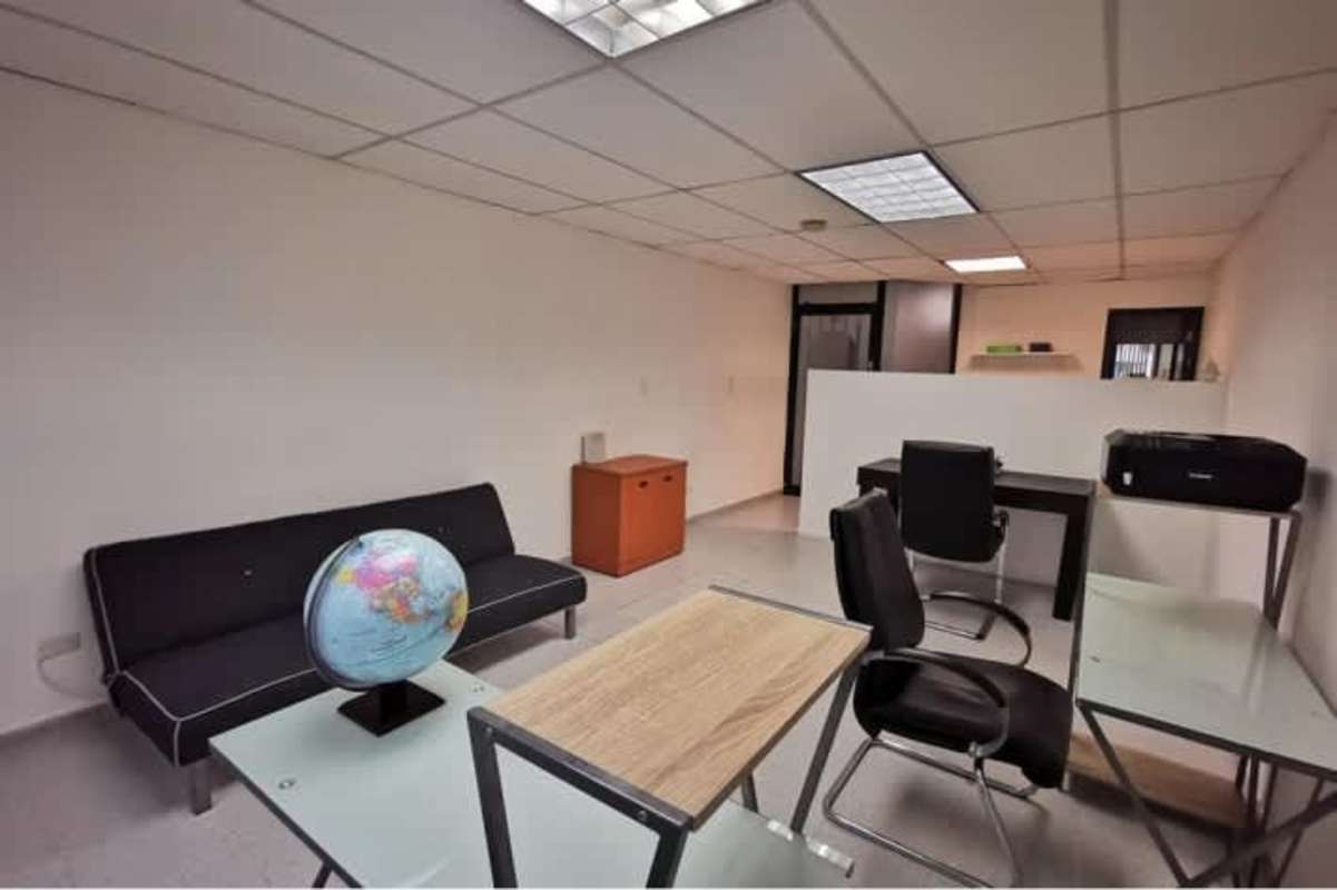 Modern open workplace with desks, chairs, futon, minimalist decor El Cangrejo