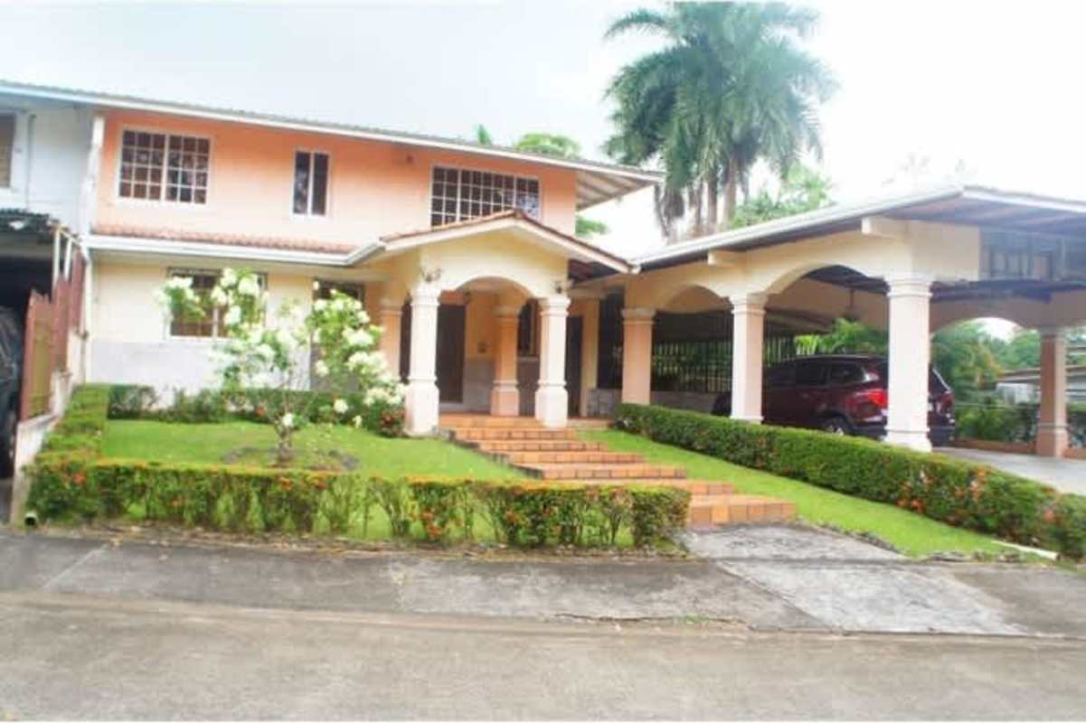 Two-story house with arched porch, carport, and landscaped yard Los Rios Corozal Panama