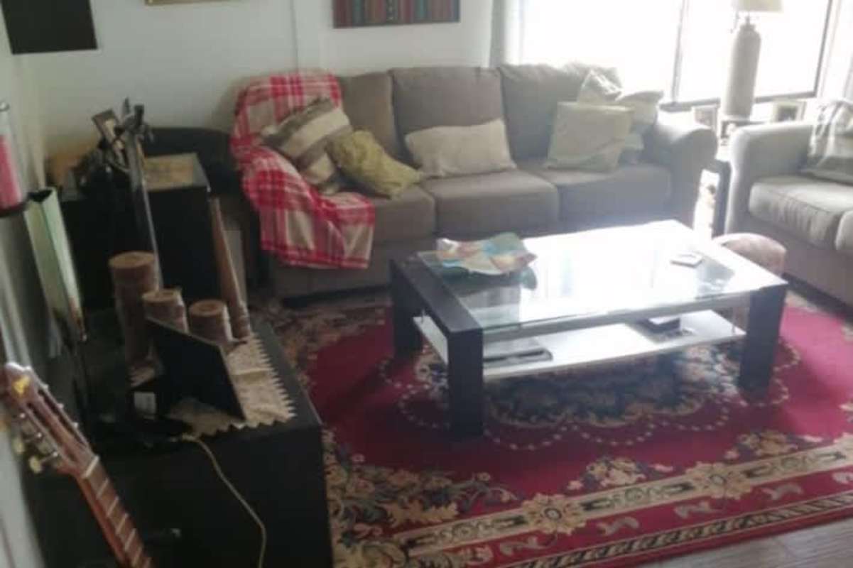 Mountain home living room with large sectional sofa, big window, decorative carpet Altos de Cerro Azul Panama