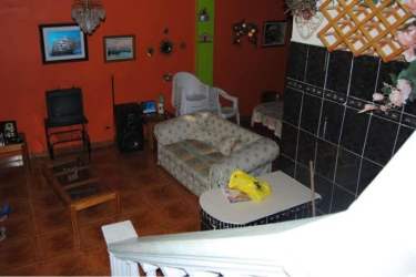 Living room eclectic décor with orange wall, black tiles in beachfront house Playa Farallón Panama