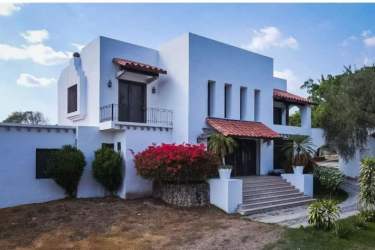 Front view Mediterranean house with red tile roof, grand staircase at Punta Barco beach estate Panama