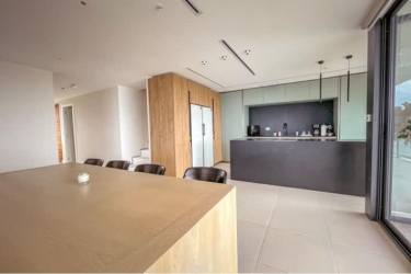 Contemporary open-plan kitchen and dining area in Punta Caelo luxury penthouse Panama, with island and appliances