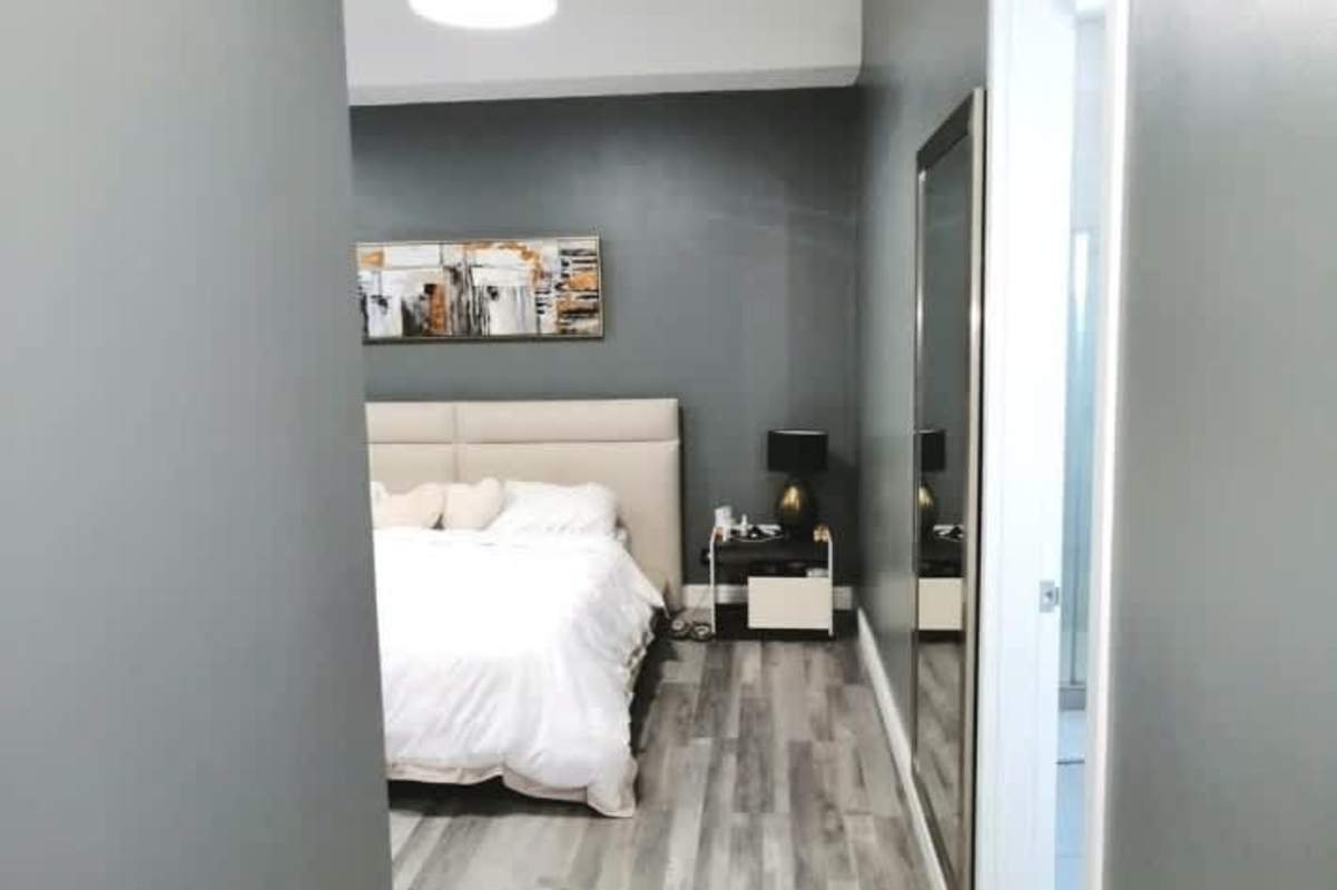 Luxury bedroom with gray walls, large wall mirror, abstract art in Dos Mares Betania Panama City