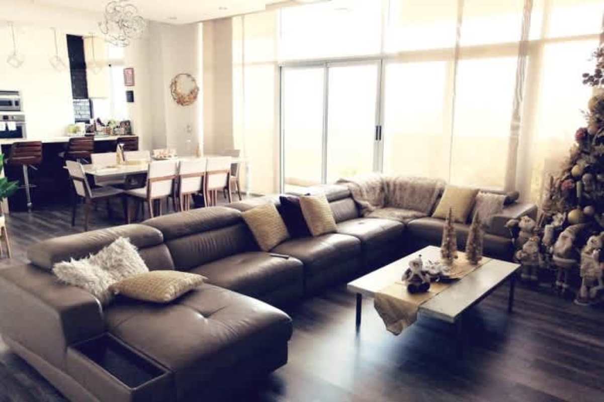 Modern spacious living dining area with sectional sofa, Christmas decor, and parquet floors Dos Mares Panama