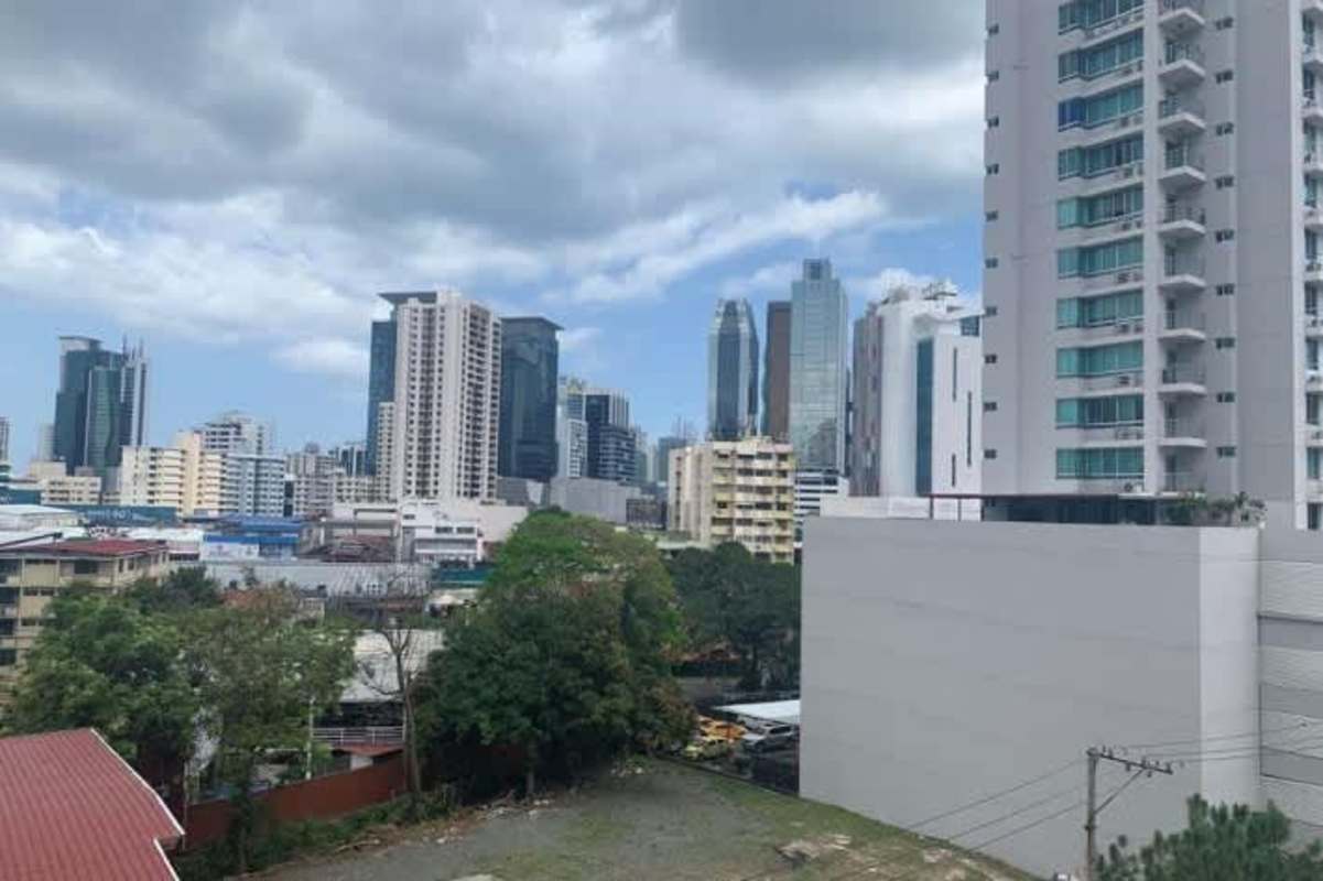 Second bedroom with tiled floors and a large window facing Panama City skyline in PH Zaphiro