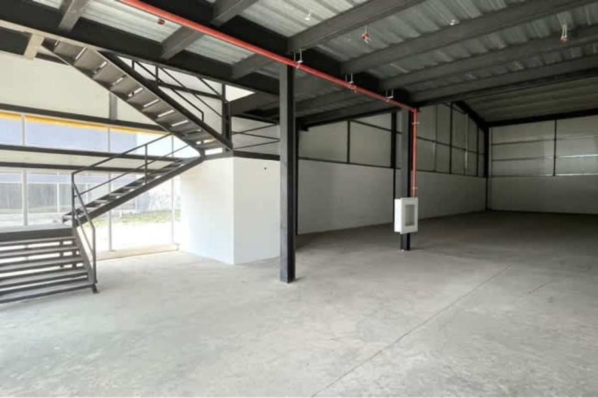 Warehouse interior featuring open space, high ceilings, metal stairs, windows for light Juan Díaz Panama