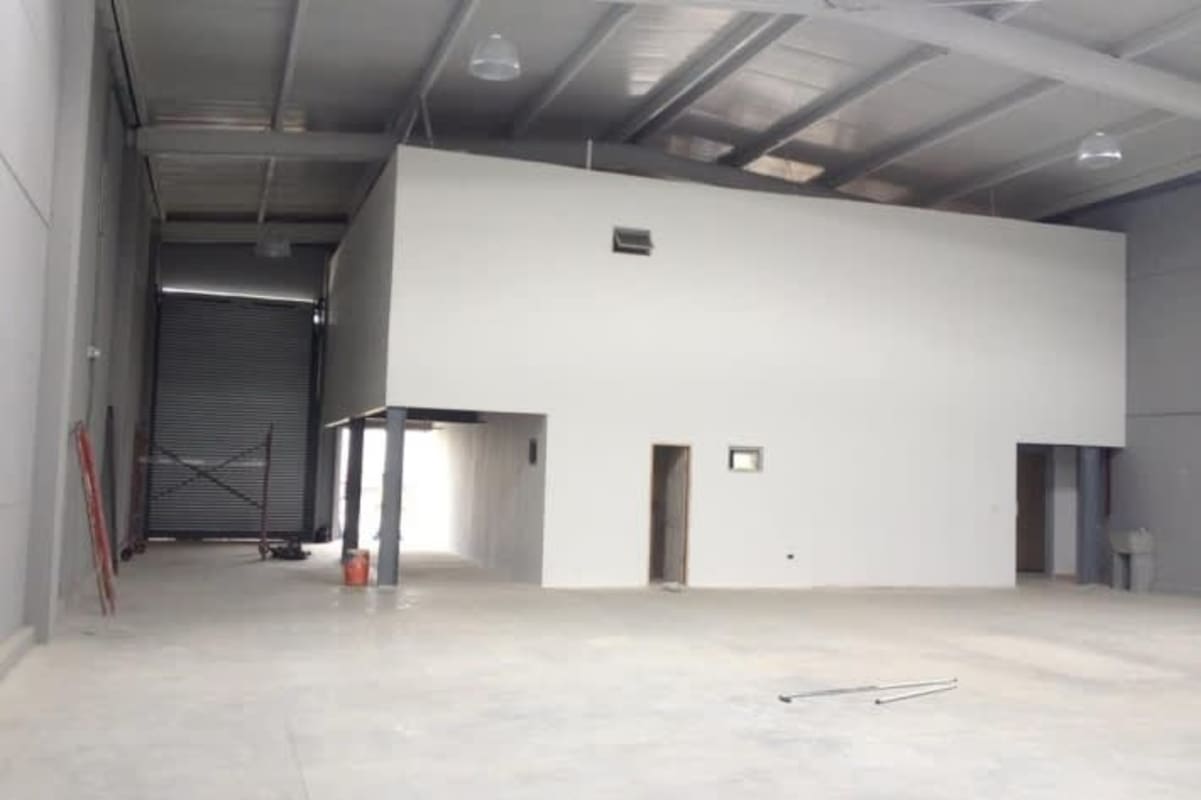 Loading docks with roller doors and parking spaces outside industrial warehouses in business park Panama City