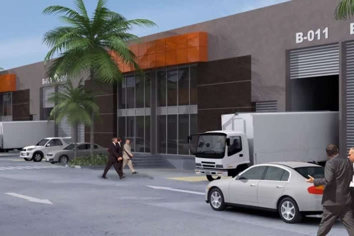 Warehouse loading dock area with truck ramps, parking, palm trees in Panama