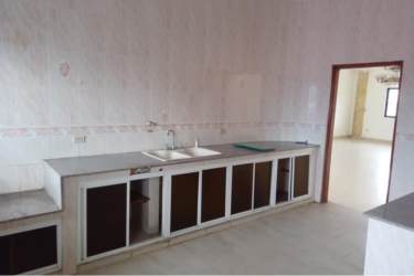 Kitchen with concrete countertop, tiled walls, open under-counter storage at PH Montelirio Colon Panama