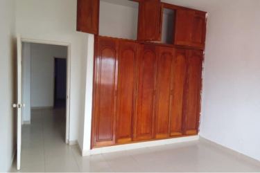 Spacious bedroom with wooden wardrobe, AC unit, tiled floor at PH Montelirio Colon Panama