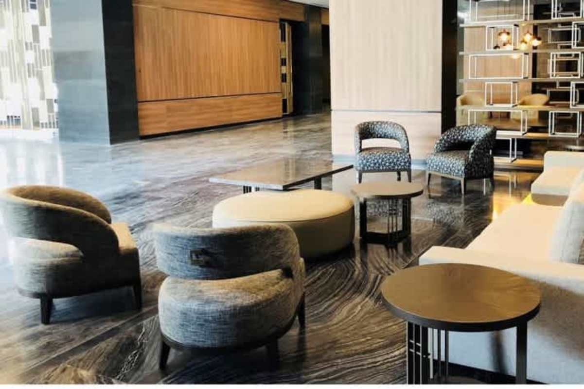Modern business lobby with marble floor, lounge seating and decorative divider in PH Panama Business Tower