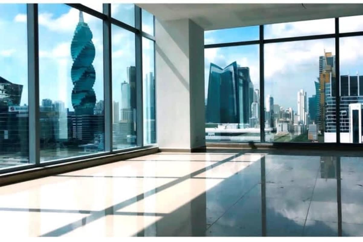 Open workspace with floor to ceiling windows overlooking city skyline at Panama Business Tower