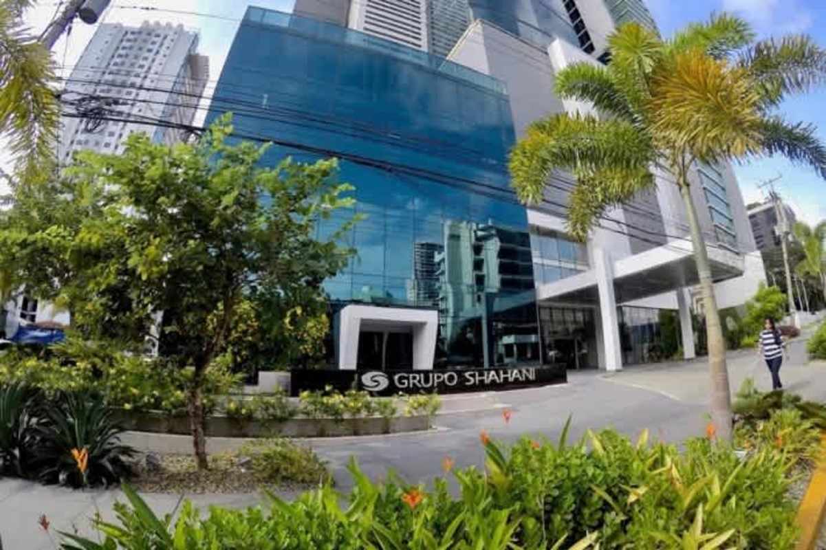 Contemporary exterior of Panama Business Tower with glass facade and landscaped entrance in Obarrio Panama City