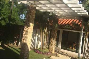 Glowing swimming pool and hot tub with landscape lighting at night in luxury Coronado Panama villa