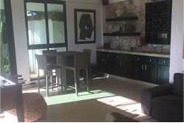 Contemporary living lounge with accent stone wall, dining area, natural light in Panama Coronado villa rental