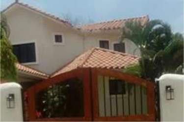 Mediterranean villa in Coronado with tile roof, wooden gate, palm trees, white walls