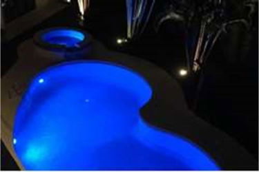 Tropical style villa entrance with palm thatch roof, natural stone columns, glass doors in Coronado