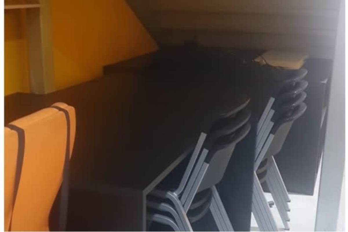 Compact study desk area under staircase with black desks and chairs at Obarrio Plaza Panama