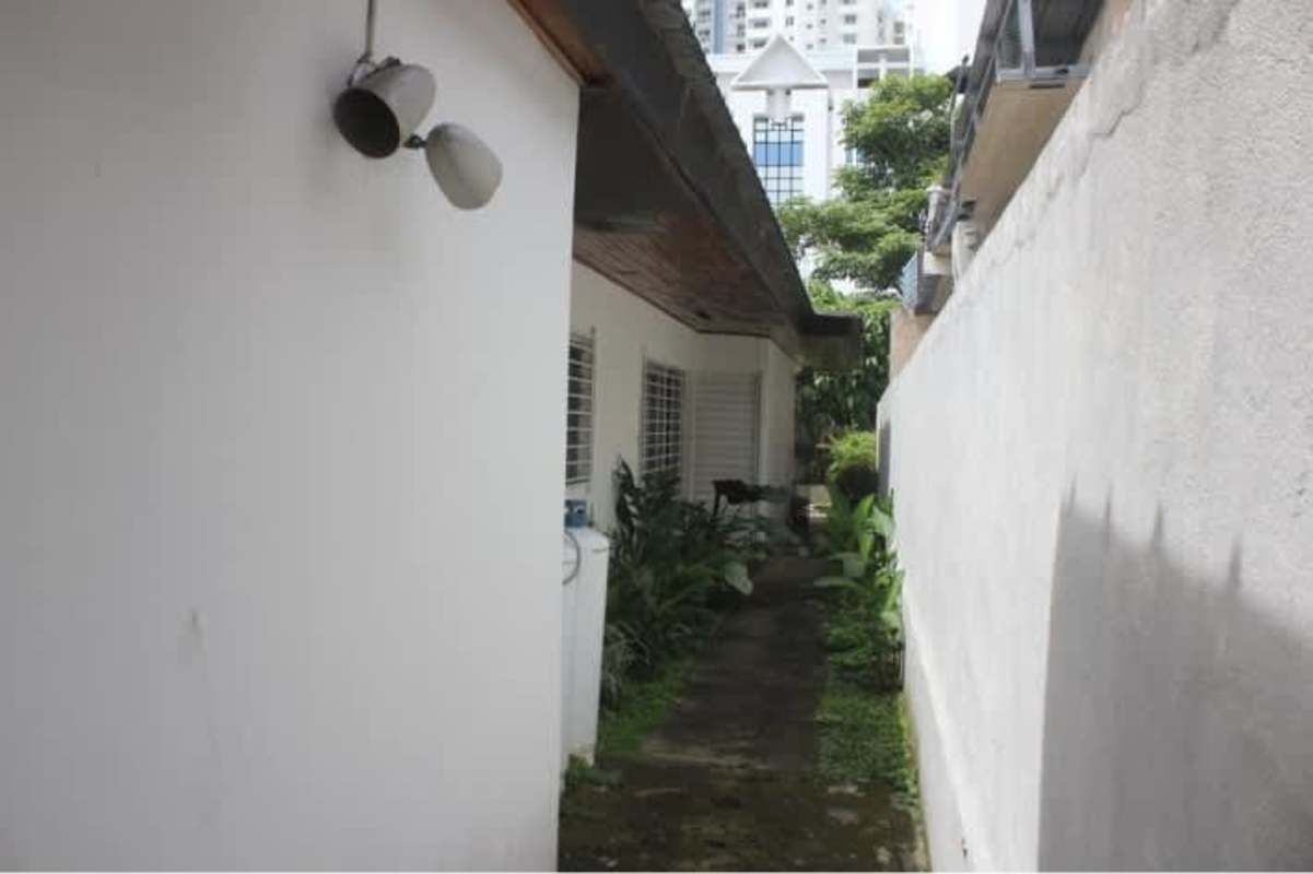 Side walkway with garden plants, white wall with barred windows Betania commercial rental