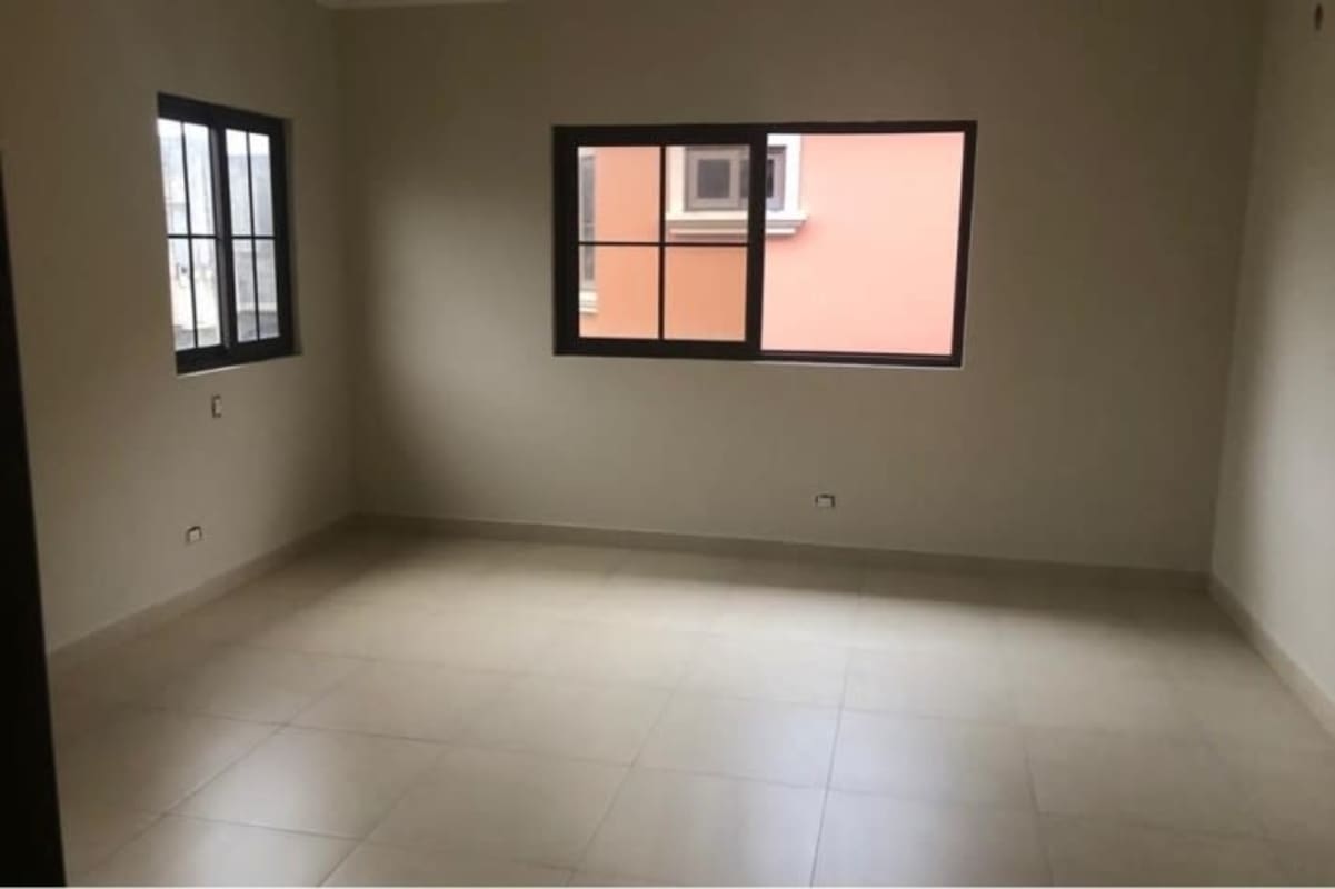 Empty bedroom with tiled floor, large window and neutral walls in Costa Sur Panama house