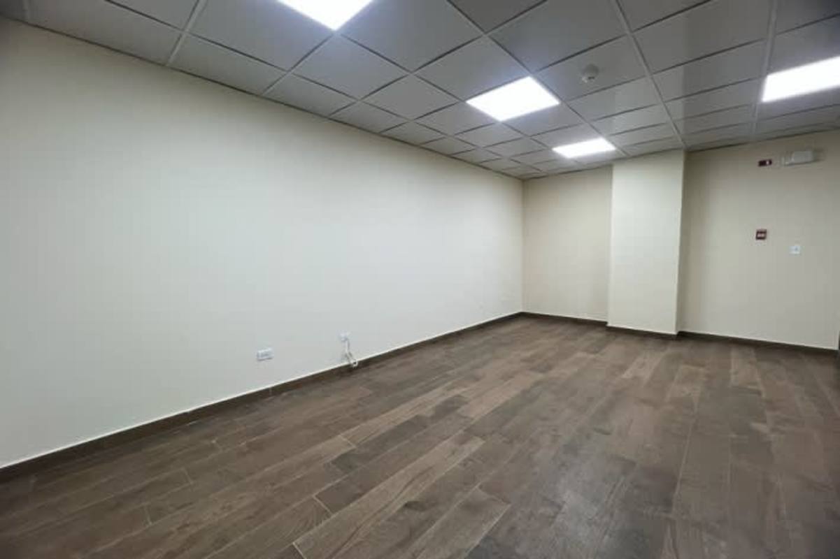 Simple bathroom with pedestal sink, tile walls, decorative border inside rental office PanCanal Plaza Panama