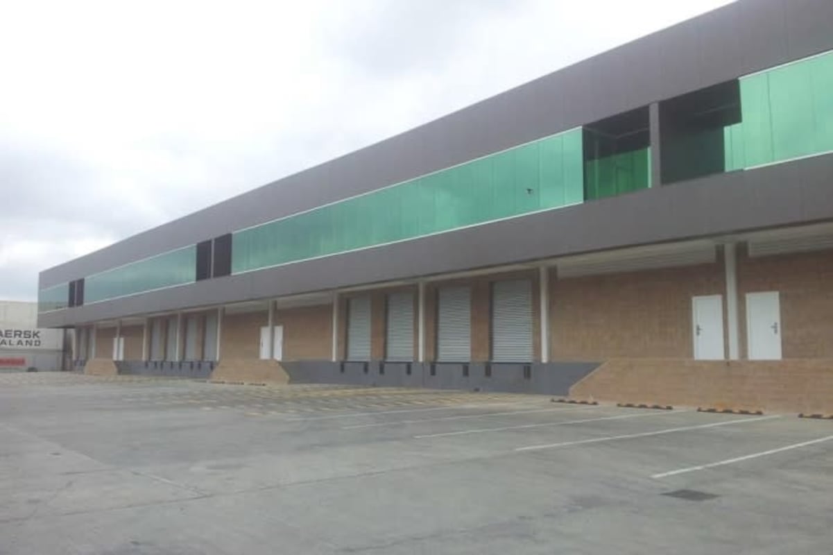 Modern industrial warehouse rear exterior with green glass windows multiple docks Panama Milla 8