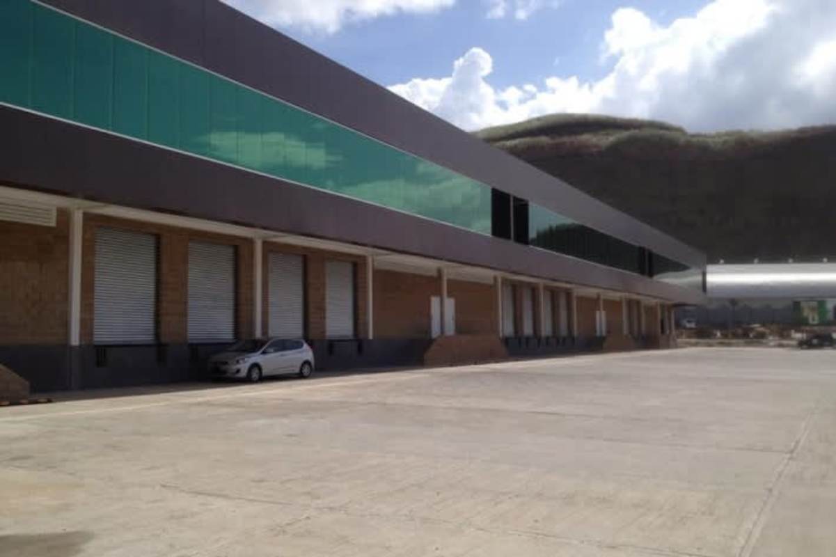 Exterior view industrial warehouse with loading bays, ample driveway, hills background in San Miguelito Panama