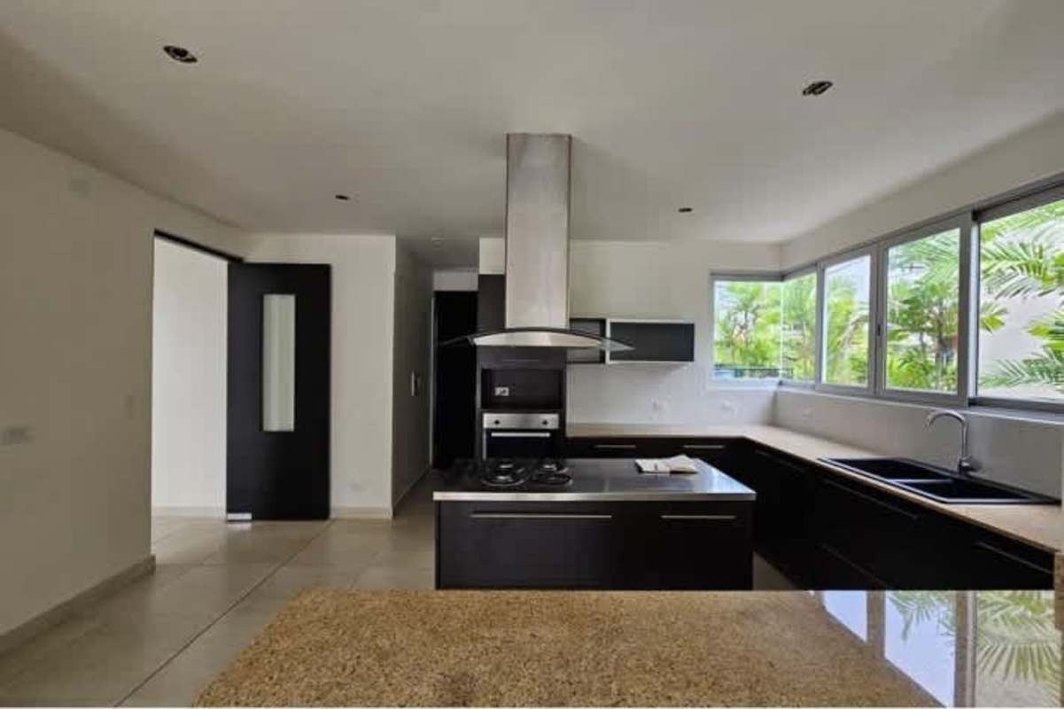Resort-style swimming pool with lounge chairs and palm trees at Villa Sur Costa Sur residential complex Panama