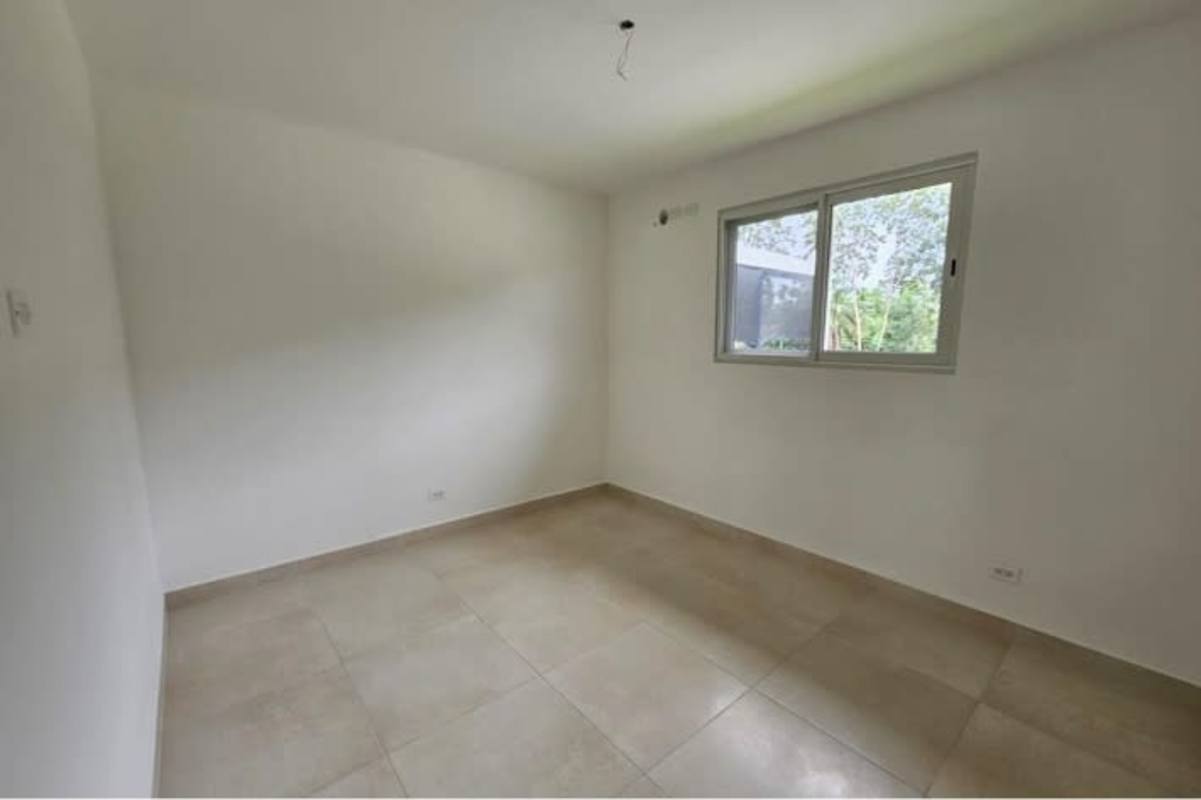 Bedroom with big window neutral floors overlooking garden at Villa Sur Costa Sur Panama