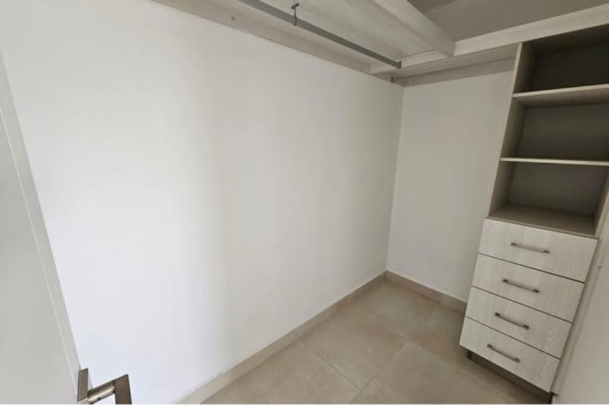 Modern walk-in closet with built-in shelves and drawers Villa Sur Costa Sur Panama