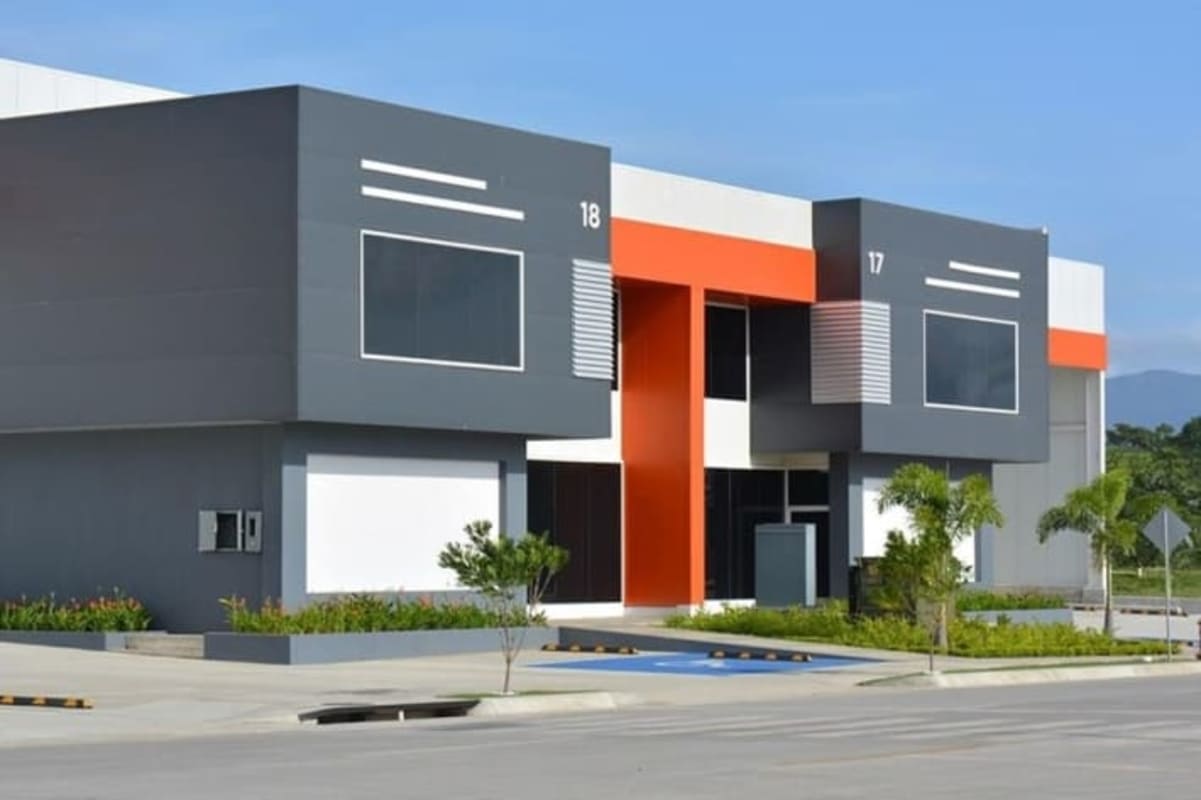 Modern facade with warehouse commercial spaces, glass windows and orange accents in Panapark Free Zone Panama