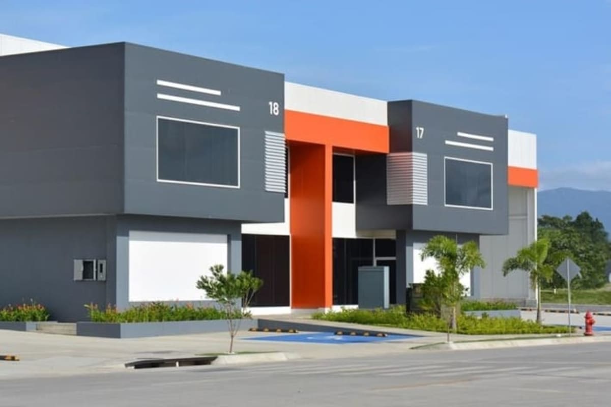 Gray and orange commercial building with glass windows and landscaped front Panapark Free Zone Panama