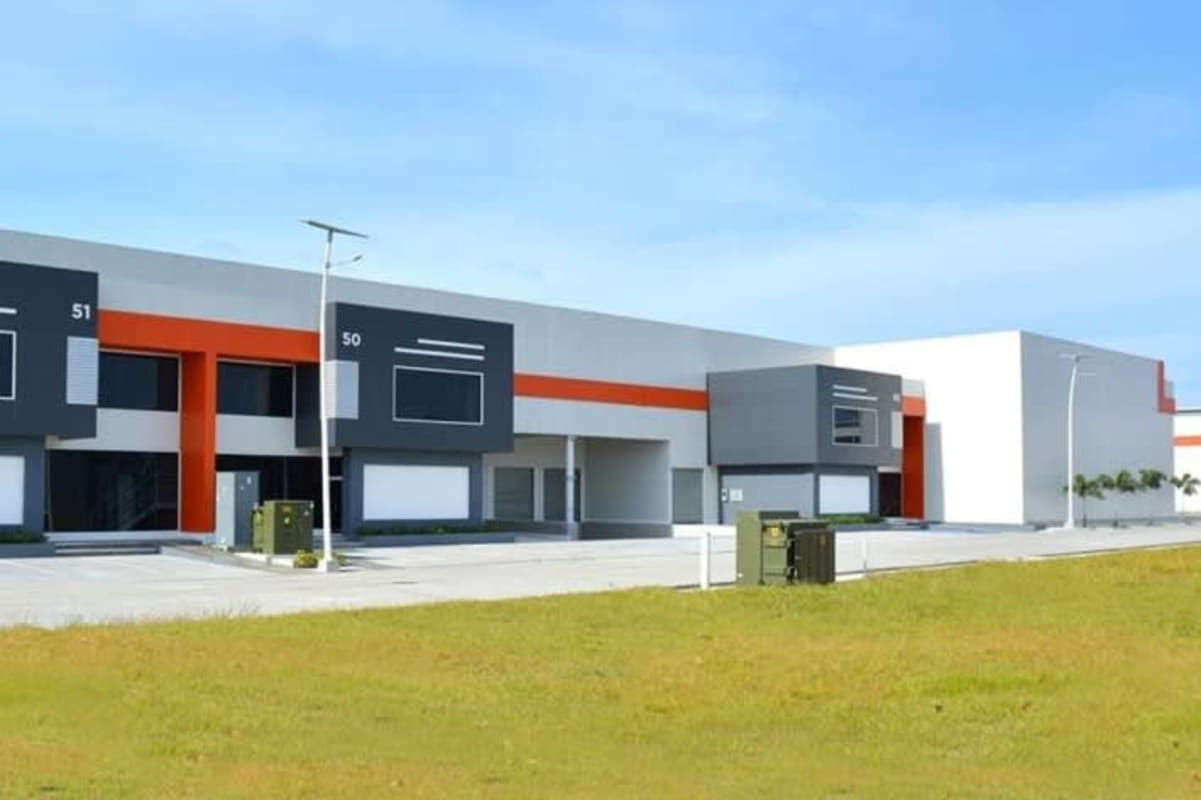 Contemporary warehouse facility with large windows, orange accents, and parking in Panapark Free Zone Panama