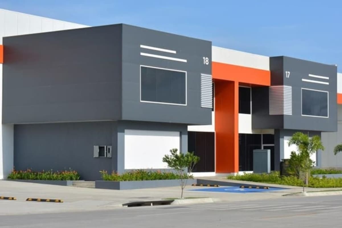 Warehouse facility with geometric windows, orange accents, parking spaces in Panapark private Free Zone Panama