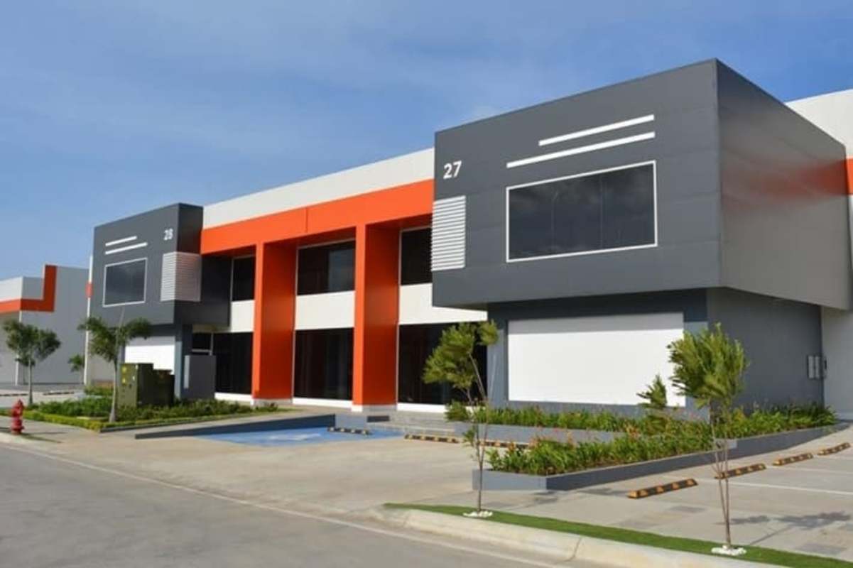 Modern white and orange facade industrial warehouse with large bays in Panama's Panapark Free Zone