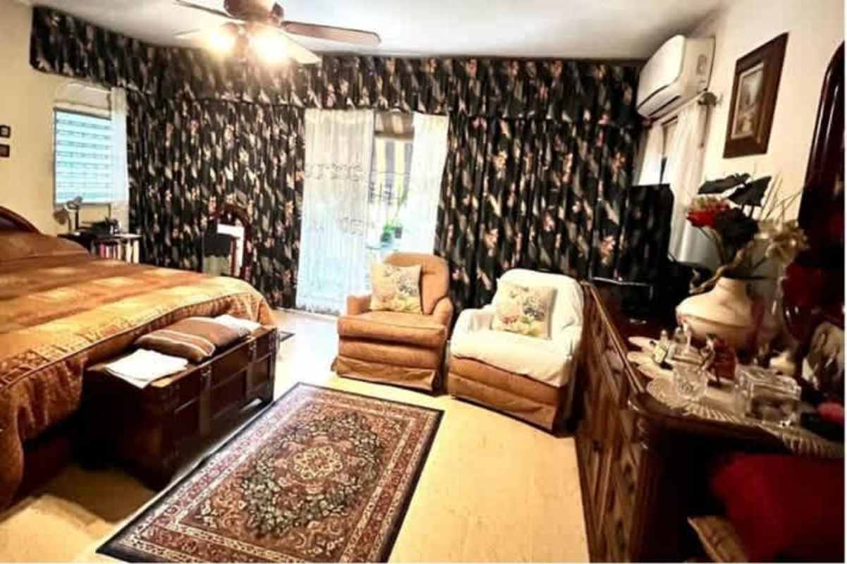 Spacious main bedroom with balcony access and traditional decor in Panama home