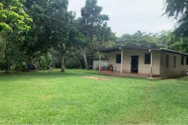 Rural single story home with porch and green surroundings in farm Capira Panama