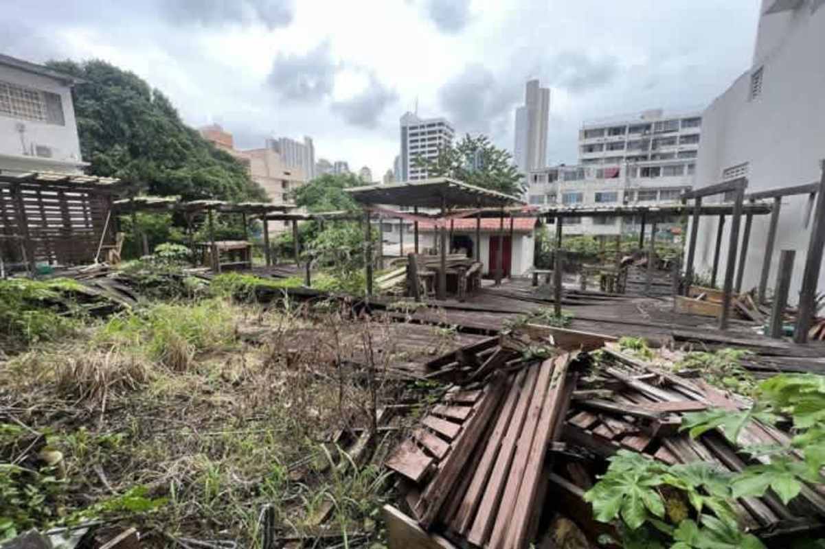Vacant overgrown lot wooden structures view of city skyline for commercial redevelopment Panama City